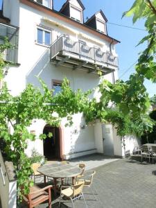 a patio in front of a white building with a table at Ferienwohnungen Schneider-Kettern in Neumagen-Dhron