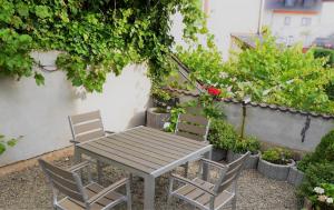 a table and chairs in a garden with plants at Ferienwohnungen Schneider-Kettern in Neumagen-Dhron +12 photos