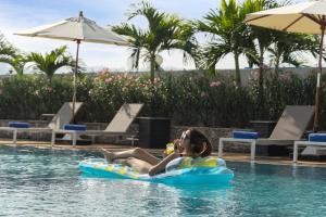 een vrouw die op een vlot in het water van een zwembad ligt bij Royal Phuket City Hotel in Phuket