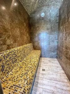 een badkamer met een geel bankje in de douche bij Oak Pearl in Dŭben