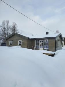 ein Haus mit Schnee davor in der Unterkunft Wake up to the silence and beauty of the Lyngen Alps in Indre Tomasjord