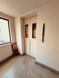 501札幌駅と大通駅も徒歩圏内な最高な立地最大2名様まで快適にご宿泊可能です في سابورو: غرفة فارغة فيها بابين ونافذة