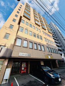 501札幌駅と大通駅も徒歩圏内な最高な立地最大2名様まで快適にご宿泊可能です في سابورو: مبنى به سيارة متوقفة أمامه