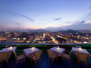 2 tafels en stoelen op een balkon met uitzicht bij Royal Phuket City Hotel in Phuket