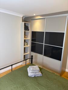 een slaapkamer met een groen bed met een glazen deur bij The Old Pitman's house in Ollerton