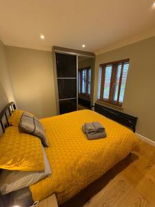 een slaapkamer met een geel bed en 2 handdoeken erop bij The Old Pitman's house in Ollerton +13 foto's