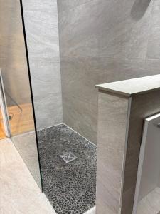 een douche met een glazen deur en een tegelvloer bij The Old Pitman's house in Ollerton