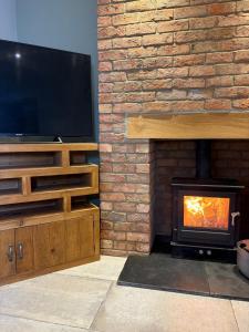 een woonkamer met open haard met televisie en open haard bij The Old Pitman's house in Ollerton