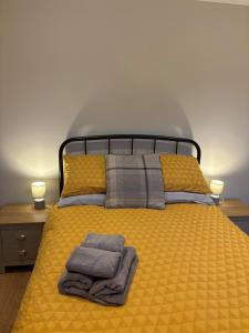 een slaapkamer met een geel bed en handdoeken bij The Old Pitman's house in Ollerton
