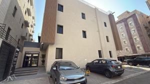 due auto parcheggiate davanti a un edificio di Ram101 a Gedda
