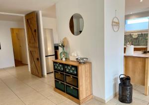 a kitchen with a table with a mirror on the wall at L'abreuvoir de la Mer- villa - plage in Sangatte