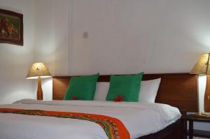 a bedroom with a large bed with green pillows at Masai Apartments Diani in Ukunda +23 photos