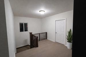 einen leeren Flur mit einer Treppe und einer weißen Tür in der Unterkunft Hollywood Comfort Vibe LA in Los Angeles