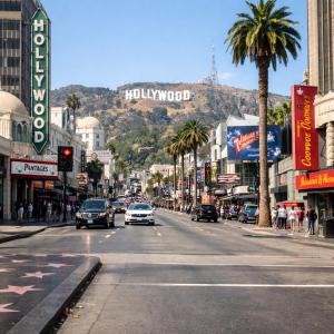 eine belebte Stadtstraße mit einem Hollywood-Schriftzug auf einem Berg in der Unterkunft Hollywood Comfort Vibe LA in Los Angeles
