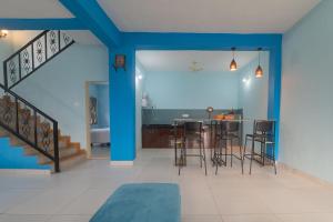 a living room with blue walls and a bar with stools at Saachi Villa in Panchgani