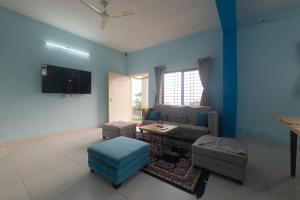 a living room with a couch and a tv at Saachi Villa in Panchgani