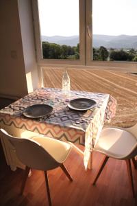 una mesa con 2 sillas y una mesa con 2 platos en La Colombière - Montélimar en Montélimar