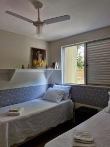 a bedroom with two beds and a window at Aconchego in Maringá