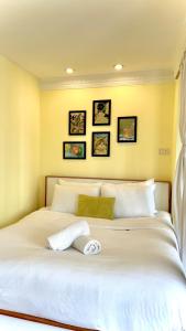 a bedroom with a large white bed with four pictures on the wall at Hanoi Brilliant Home in Hanoi