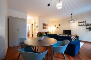 Giudecca Suite في البندقية: غرفة معيشة مع طاولة وكراسي زرقاء