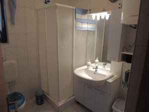 a white bathroom with a sink and a shower at Apartmani Antonela&Andrej in Privlaka +105 photos