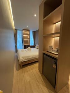 een kleine kamer met een bed en een laptop op een aanrecht bij The Warehouse Chiang Mai in Chiang Mai