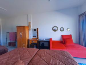 un salon avec un canapé et un canapé rouge dans l'établissement บ้านพักคุณอร, à Ban Ku Sua