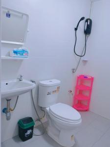 une salle de bain avec toilettes et un téléphone mural dans l'établissement บ้านพักคุณอร, à Ban Ku Sua
