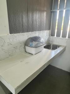 un appareil assis sur un comptoir à côté d'un évier dans l'établissement บ้านพักคุณอร, à Ban Ku Sua