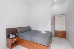 een slaapkamer met een bed, een ladekast en een spiegel bij SG Hotel Pangandaran in Pangandaran