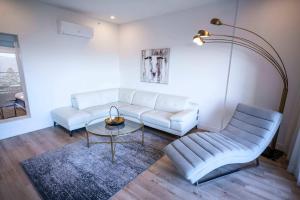 een woonkamer met een witte bank en een tafel bij 304 - Chic Minimalist Condo - River & Serenity in Baie-Saint-Paul
