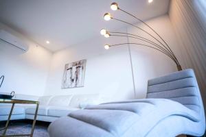 een woonkamer met een witte bank en een tafel bij 304 - Chic Minimalist Condo - River & Serenity in Baie-Saint-Paul