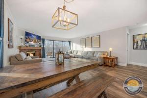 ein Wohnzimmer mit einem Holztisch und einer Couch in der Unterkunft Modern Lake Geneva Condo with Year-Round Views in Lake Geneva + 33 Fotos