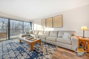 ein Wohnzimmer mit Sofa und Tisch in der Unterkunft Modern Lake Geneva Condo with Year-Round Views in Lake Geneva