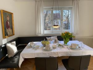 a dining room table with a white table cloth at Haus Hirt - Idyllisch wohnen zwischen Augsburg und München in Klosterlechfeld +15 photos
