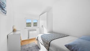 een witte slaapkamer met een bed en een raam bij Villa Pleter by Villas Guide in Otavice +59 foto's