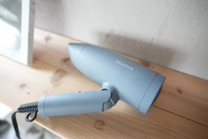 a blue hair dryer sitting on a wooden table at Base House Kinosaki - Vacation STAY 68122v in Tsuiyama