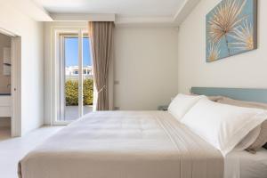 een slaapkamer met een groot bed en een raam bij Radiluxe - Villa Marlux in Marina di Pescoluse +52 foto's