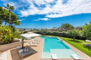 een buitenzwembad met ligstoelen en een zwembadvisor bij Radiluxe - Villa Marlux in Marina di Pescoluse