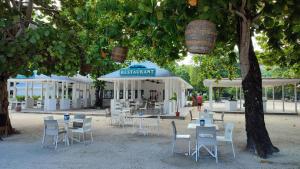 een groep tafels en stoelen onder een blauwe paraplu bij Sunny dream in Sandy Bay