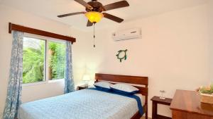 een slaapkamer met een bed en een plafondventilator bij Sunny dream in Sandy Bay +37 foto's