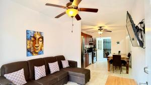 een woonkamer met een bank en een plafondventilator bij Sunny dream in Sandy Bay