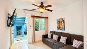 een woonkamer met een bank en een plafondventilator bij Sunny dream in Sandy Bay