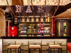 een bar met houten tafels en stoelen in een kamer bij ibis Styles London Southwark - near Borough Market in Londen