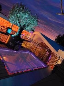a swimming pool in front of a house at night at La Renaissance - Deux gites de standing in Herve