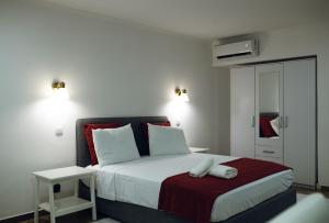 a bedroom with a large bed with a red blanket at Onzo Yamy in Luanda +265 photos