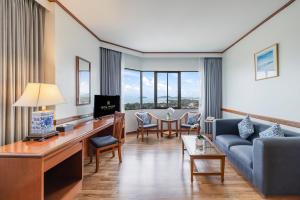 een woonkamer met een bank en een tafel bij Royal Phuket City Hotel in Phuket