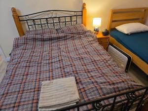 uma cama com um cobertor xadrez num quarto em Colchester Hythe home em Hythe