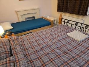 um quarto com uma cama com um cobertor xadrez em Colchester Hythe home em Hythe