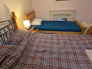 um quarto com uma cama com um cobertor xadrez em Colchester Hythe home em Hythe